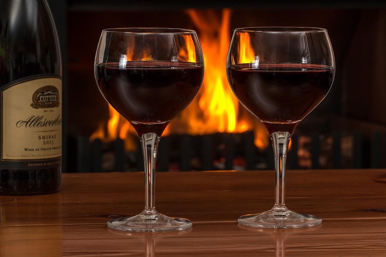 Copas de vino ante chimenea